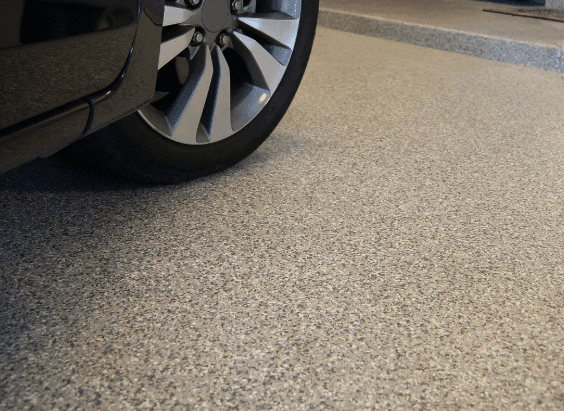 Close-up of a vehicle on a tan flake epoxy garage floor